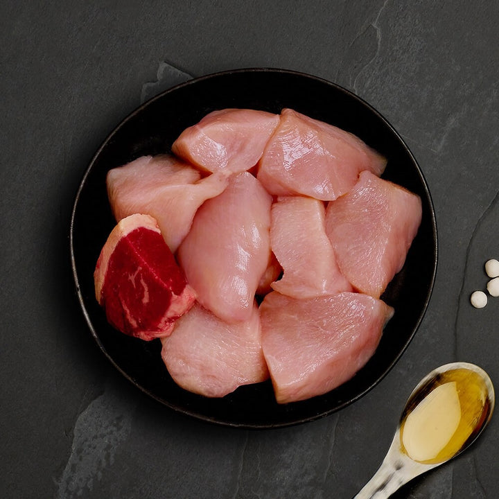 Fresh chicken and a piece of beef, the ingredients in Canagan Chicken with Beef for cats