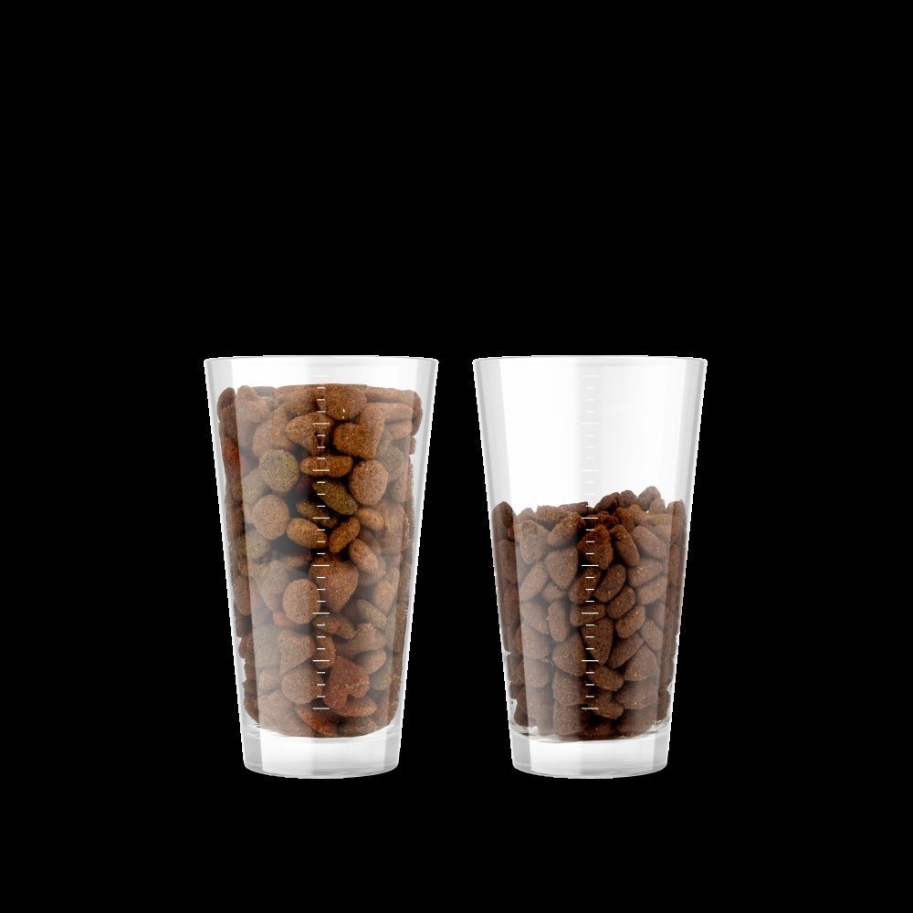 Feed up to 30 percent less: a glass of typical cheaper food beside a smaller glass of Canagan Chicken